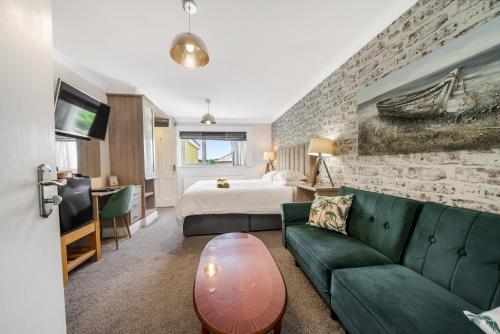 a hotel room with a green couch and a bed at Anvershiel House in Portrush
