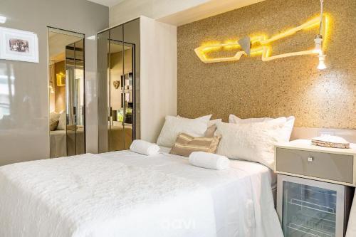 a bedroom with a large white bed and a tv at Apt. Beira Mar em Cotovelo In Mare 137 - QAVI in Granja Beira Mar