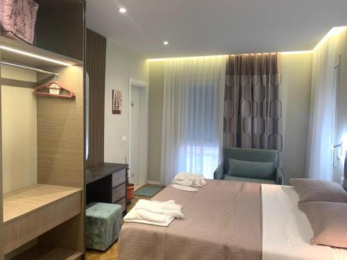 a bedroom with a bed and a chair and a mirror at Tirana Magnifique Apartments in Tirane