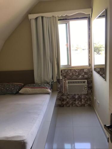 a small room with a bed and a window at Chalé Beira Mar - Tamandaré in Tamandaré