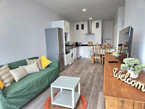 a living room with a green couch and a kitchen at Ericeira Ribamar Sea View Villa in Santo Isidoro
