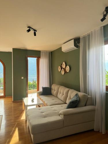 a living room with a couch and a large window at Sea and Mountain View - Cozy Pool Flat - Sleeps 6 in Dobrota