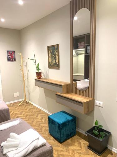 a bedroom with a mirror and a blue stool at Tirana Magnifique Apartments in Tirane