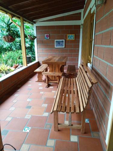 a patio with benches and a table on a brick wall at Beautiful Country - Ser feliz - House located in Llanogrande in Rionegro