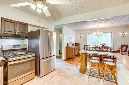 a kitchen with a stainless steel refrigerator and a table at Lakefront Group Getaway with Dock in Baldwin! in Baldwin