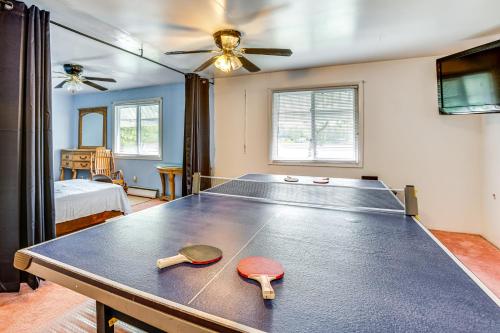 a room with a ping pong table with two paddles at Lakefront Group Getaway with Dock in Baldwin! in Baldwin