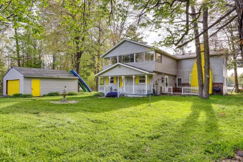 a house with a slide in the yard at Lakefront Group Getaway with Dock in Baldwin! in Baldwin