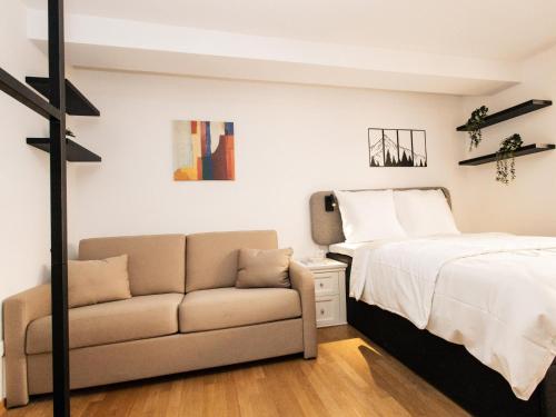 a bedroom with a bed and a couch at Hoffie und Prost in Hopfgarten im Brixental