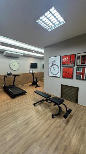 a gym with two exercise bikes and a clock on the wall at Apart Praia de Icaraí London, Vista Cristo and MAC in Niterói