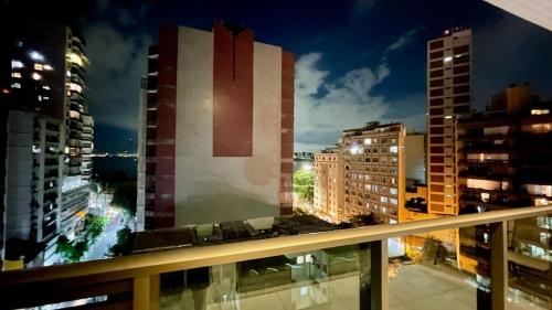 a view of a city at night from a balcony at Apart Praia de Icaraí London, Vista Cristo and MAC in Niterói