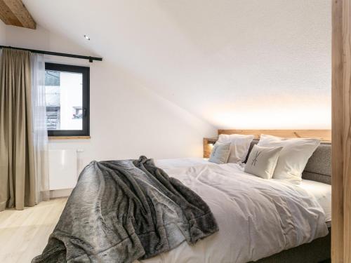 a bedroom with a bed with white sheets and pillows at Alpenlodge Pettneu Lodge 1 in Pettneu am Arlberg