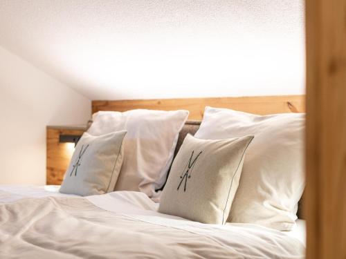 a bed with white sheets and pillows at Alpenlodge Pettneu Lodge 1 in Pettneu am Arlberg