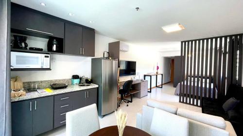 a kitchen and living room with a refrigerator and a table at Apart Praia de Icaraí London, Vista Cristo and MAC in Niterói