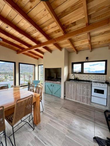 a kitchen and dining room with a wooden ceiling at Refugio del Pescador in Esquel