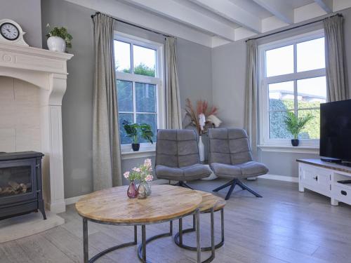 a living room with a table and two chairs and a television at t Kaatsheuveltje 5 in Sprang-Capelle