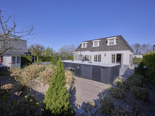 a house with a wooden deck in front of a house at t Kaatsheuveltje 5 in Sprang-Capelle