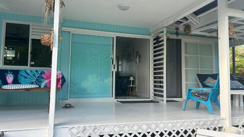 a porch with a blue house with a glass door at LE FARE eco in Tiputa