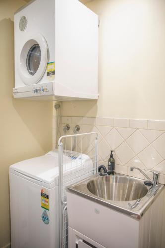a kitchen with a sink and a washing machine at Halls Gap Escape Townhouses in Halls Gap