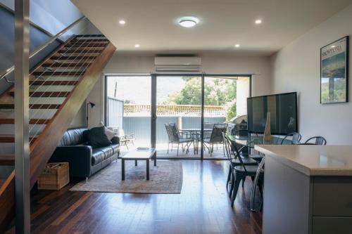 a living room with a staircase and a living room at Halls Gap Escape Townhouses in Halls Gap