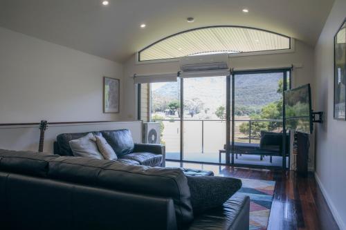 a living room with a couch and a large window at Halls Gap Escape Townhouses in Halls Gap