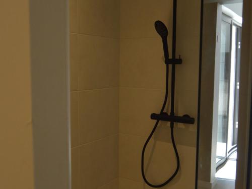 a shower with a shower head in a bathroom at Maison rénovée en Berry : terrasse, jardin privé, proche Châteauroux et nature - FR-1-591-164 in Saint-Maur
