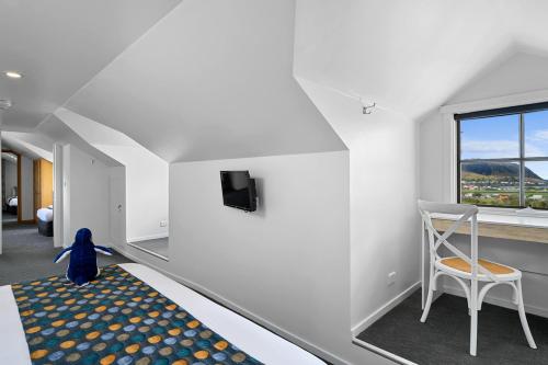 a room with a bed and a chair and a tv at Stanley Seaview Inn in Stanley