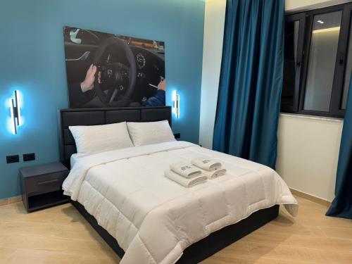 a bedroom with a bed with a car on the wall at Hotel Tuyo in Tirana