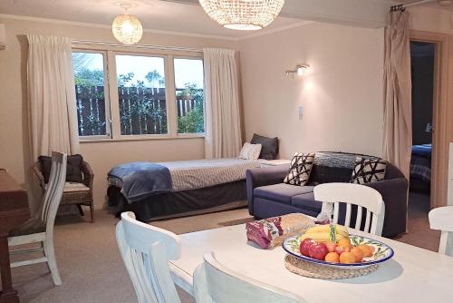 a living room with a table with a bowl of fruit at Feel at Home in Tauranga