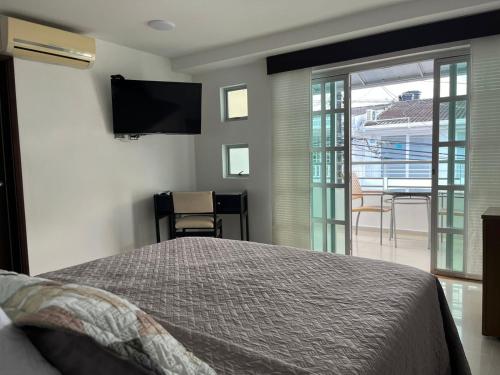 a bedroom with a bed and a flat screen tv at Hotel Villa María Coworking in Villavicencio