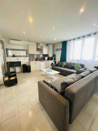 Il comprend un grand salon avec un canapé et une cuisine. dans l'établissement Entire House Paris-Stade de France, à Aubervilliers