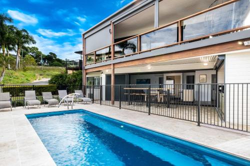 a swimming pool in front of a house at Day Dreaming - Mazlin House in Airlie Beach
