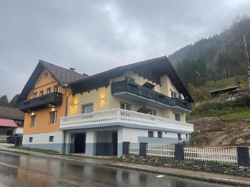 a large yellow and white building with a balcony at Grüner See Hotel & Residenzen in Oberort