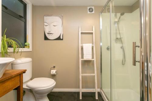 a bathroom with a toilet and a glass shower at The French Cottage Great Wifi Private in Taupo