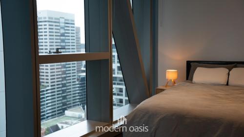 a bedroom with a bed and a large window at Modern CBD 2BR Free Gym & Pool Walk Everywhere in Melbourne