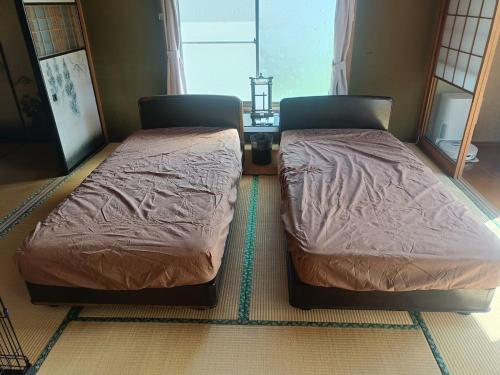 two twin beds sitting in a room at ＮＩＫＫＯワンとStay in Nikko