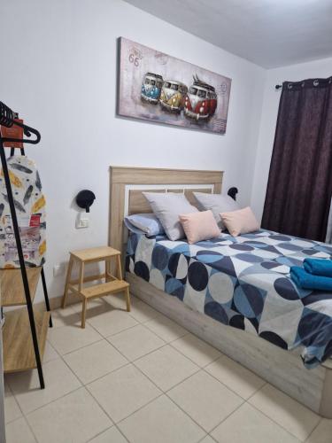 a bedroom with a bed and a painting of cars on the wall at Las Brisas in Granadilla de Abona