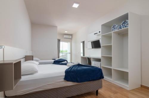 een slaapkamer met een groot bed met witte muren bij Pousada Amanhecer do Sul in Penha