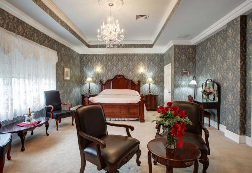 a bedroom with a bed and chairs and a table at Wilbraham Mansion in Cape May