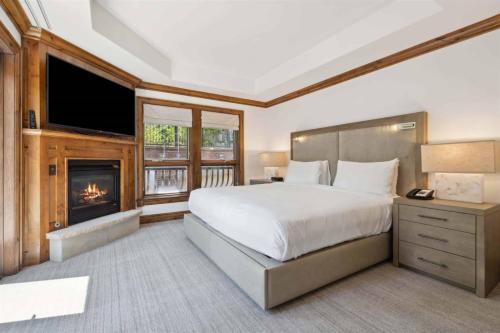 アスペンにあるAspen Mountain Residences, 2 Bedroom Luxury Residence Club Condoの大きなベッドと暖炉のある寝室