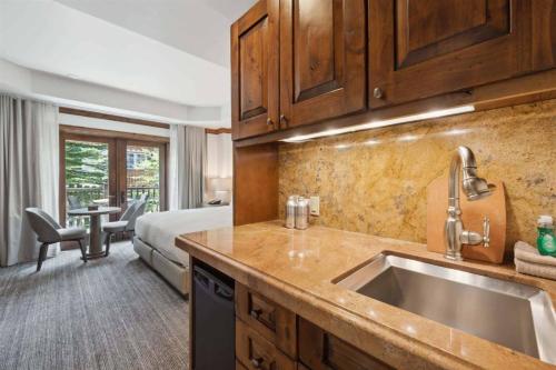 アスペンにあるAspen Mountain Residences, 2 Bedroom Luxury Residence Club Condoのシンク付きのキッチンとベッドが備わった部屋