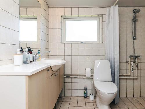 a bathroom with a toilet and a sink and a window at 6 person holiday home in Bogø By in Bogø By