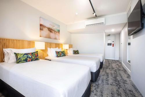 a hotel room with two beds and a tv at Nightcap at Hotel Victor in Victor Harbor