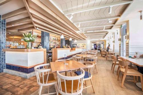 a restaurant with tables and chairs and a bar at Nightcap at Hotel Victor in Victor Harbor