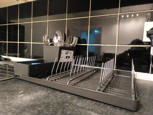 4 pers studio style room Near South Wimledon station R3 في لندن: منضدة بأدوات فضية في المطبخ