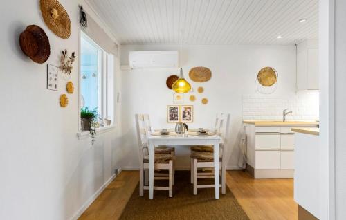 a kitchen with a white table and chairs at 1 Bedroom Awesome Home In Skagen in Skagen