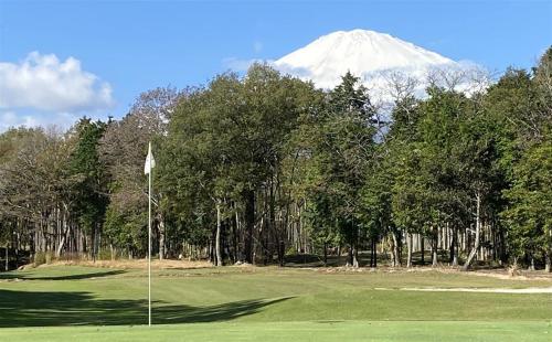 a golf course with a snow covered mountain in the background at takane no mori no cottage in Gotemba