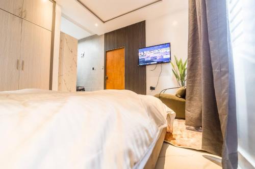 Un dormitorio con una cama y un televisor de pantalla plana. en Accra airport/pool, en Otele