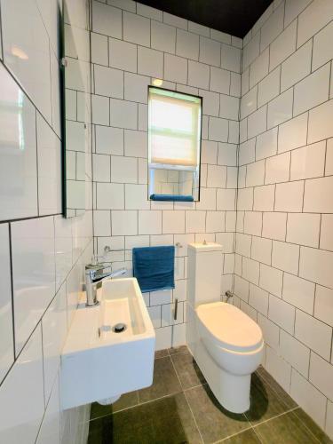a white bathroom with a toilet and a sink at Marina View in Taʼ Xbiex