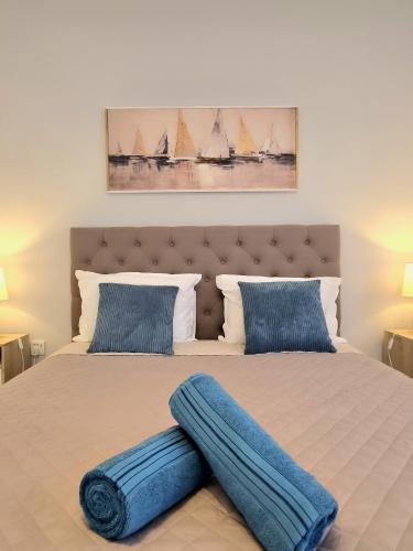 a bedroom with a large bed with blue pillows at Marina View in Taʼ Xbiex