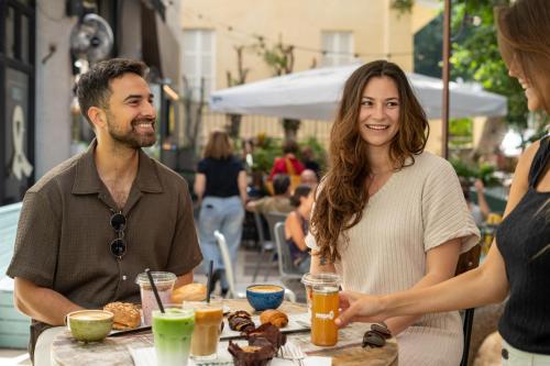 a group of people sitting at a table with food at Fiori 41-By Adam Hotels in Tel Aviv